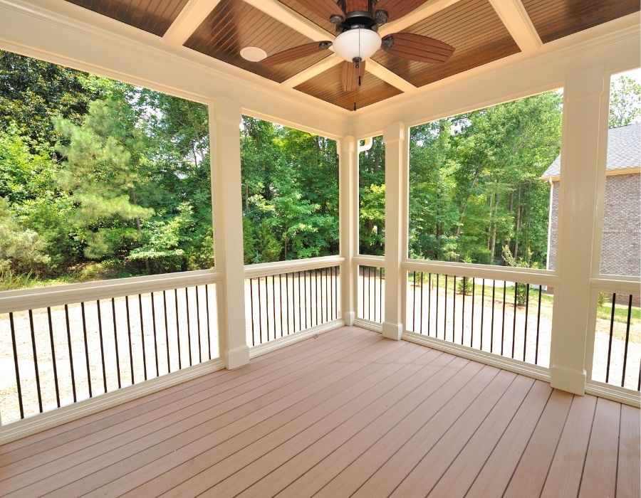 Spacious screened porch with composite decking, detailed ceiling paneling, and ceiling fan installation by Penwin Roofing and Windows in the Lowcountry, offering a stylish and functional outdoor living space
